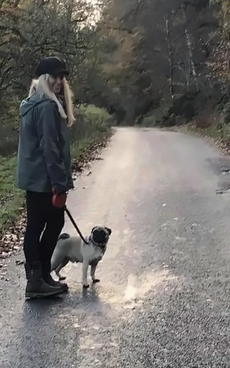 Katey Lorraine walking her pug on a woodland lane